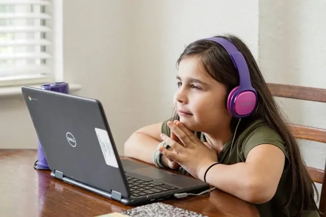 children in front of laptop in class